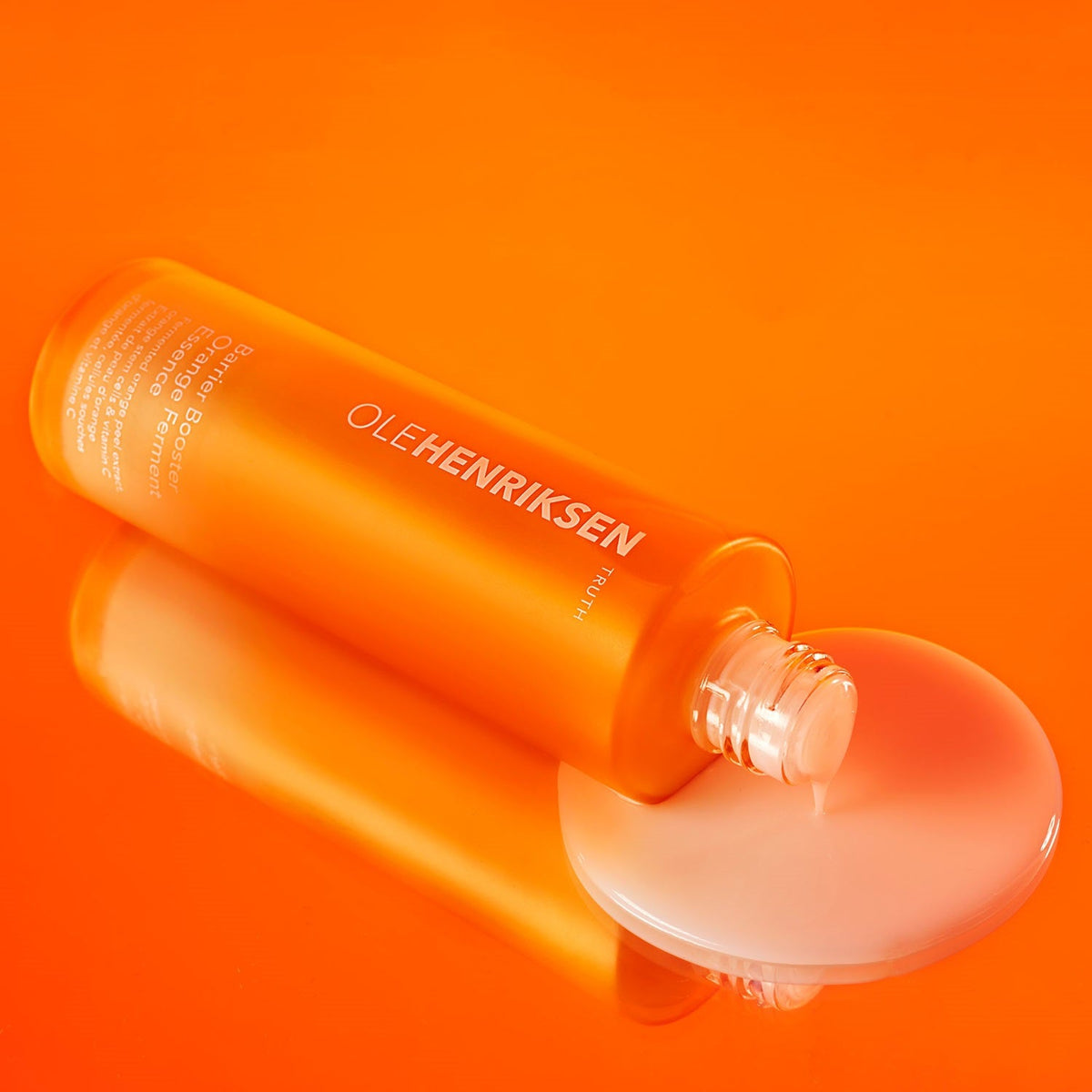 Open bottle of Barrier Booster Orange Ferment Vitamin C Essence laid down sideways.